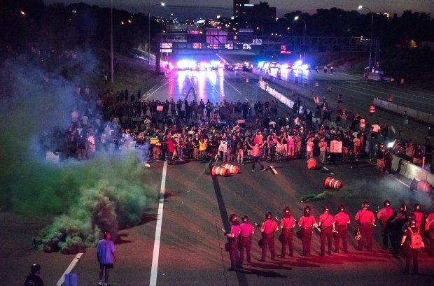 Police shoot smoke rounds after telling protesters to move off Interstate 94 near the eastbound Dale Street exit in St. Paul just before 10 p.m. Saturday, July 9, 2016. Shortly after, the line of police in riot gear moved back about half a block and continued to tell the protesters to leave. Traffic on the interstate was closed in both directions by a large group protesting the police shooting of Philando Castile, who was killed Wednesday night in Falcon Heights. (Pioneer Press: Andy Rathbun)